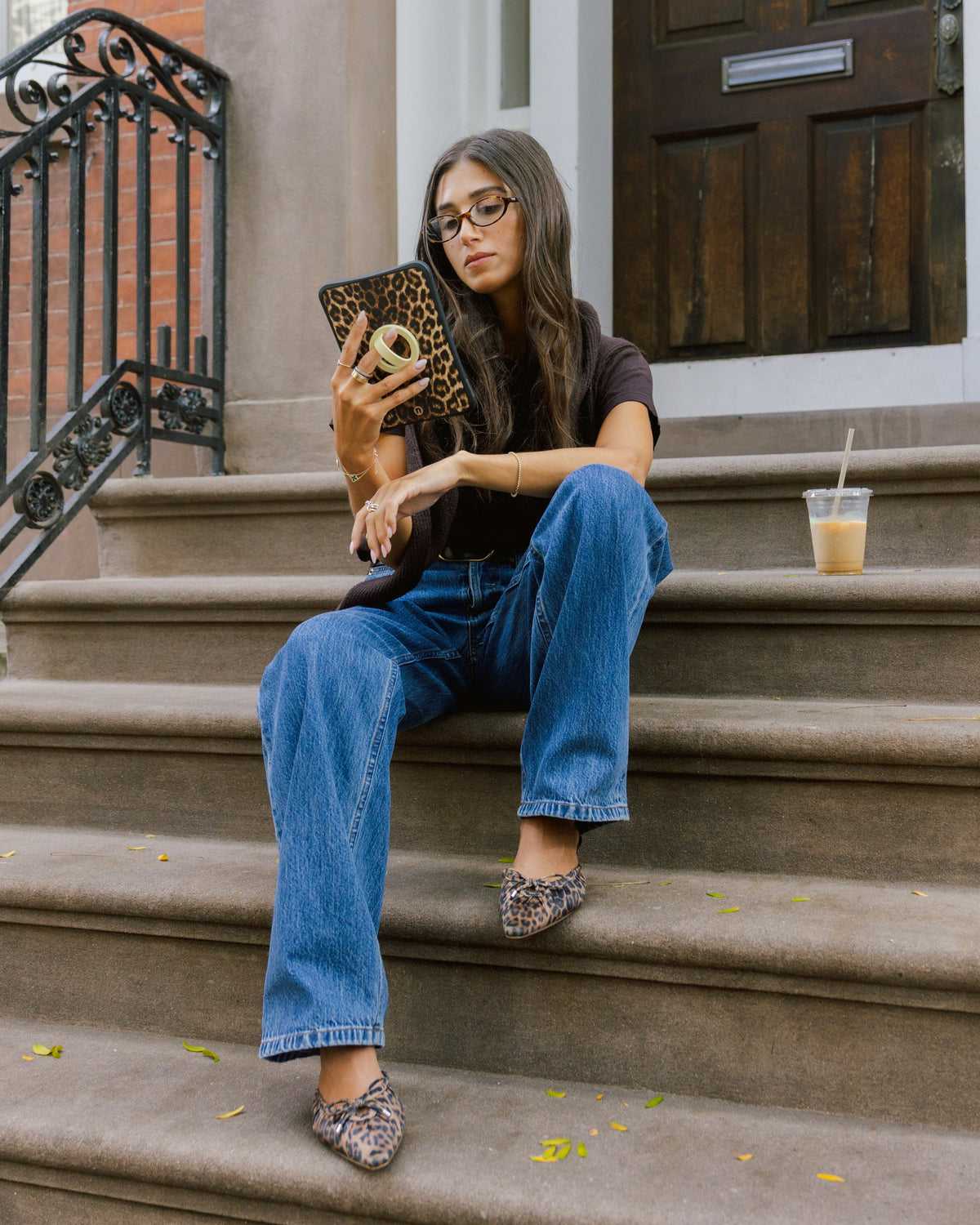 Reader on brownstone steps holding a leopard print Bondi case by its grip